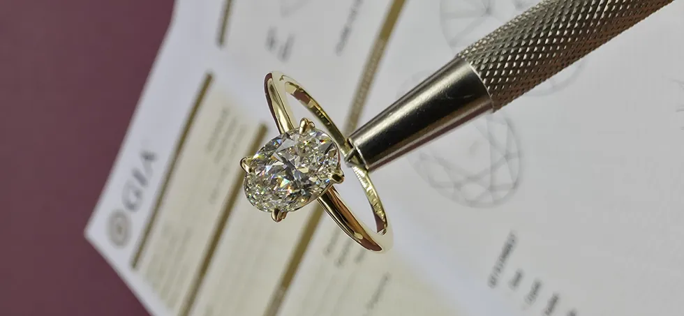 Anel solitário de ouro sobre o laudo de classificação de diamante do GIA
